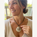 Psamathe necklace worn by Jeni: smoky brown stone beads, bronze toggle clasp and a calico scallop shell pendant
