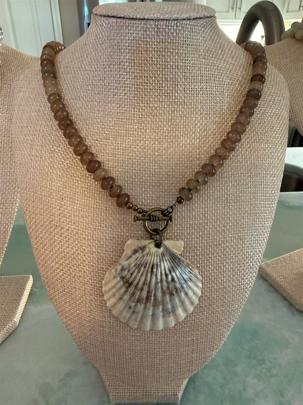 Psamathe necklace on a linen bust display