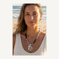 Nyx necklace worn by Jeni on the beach: black labradorite fragments, Picasso jasper, clear glass beads and an oyster shell pendant